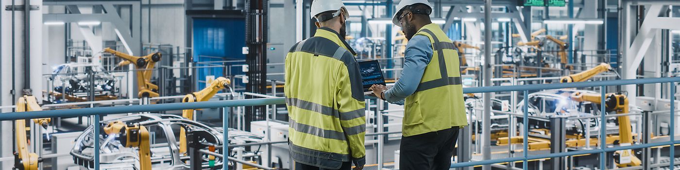 Two workers in a car manufacturing plant