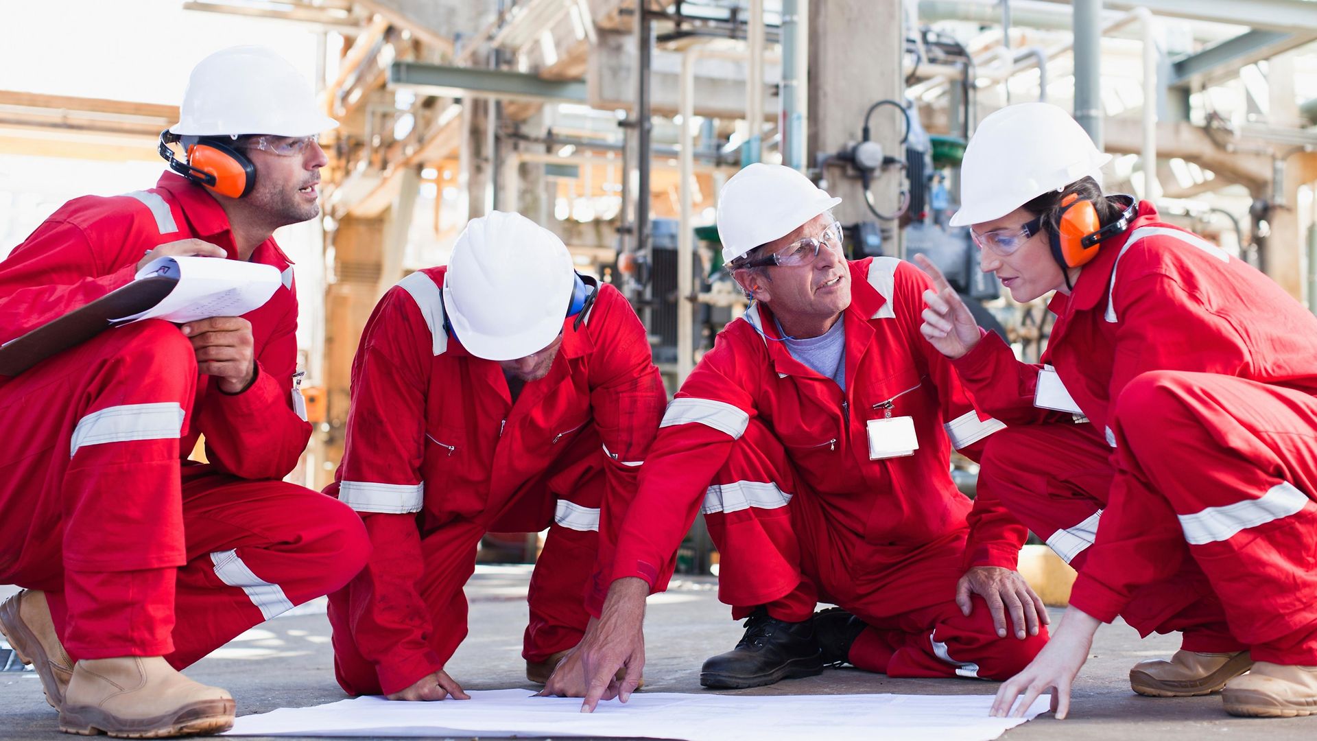 refinery workers reviewing blueprint outside plant chemical plastics recycling-scalability