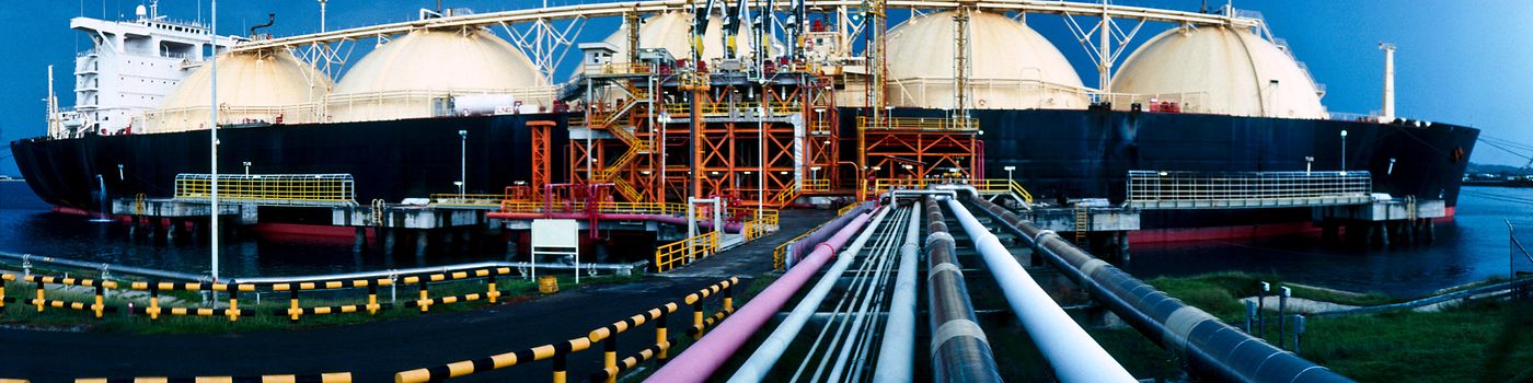 LNG tanker at port with pipes connected from onshore